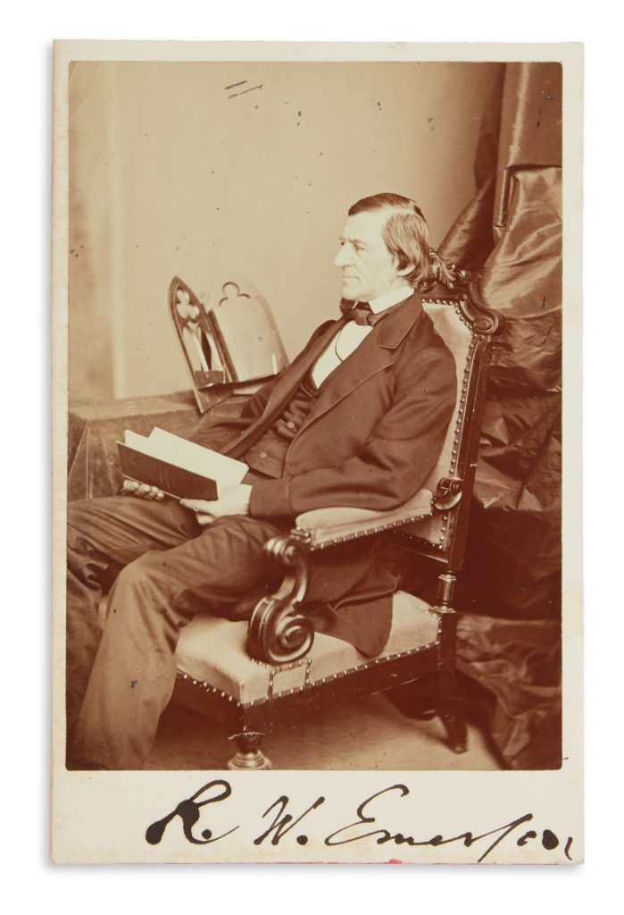 Lot 324, signed photograph of Ralph Waldo Emerson sitting in a chair with a book.