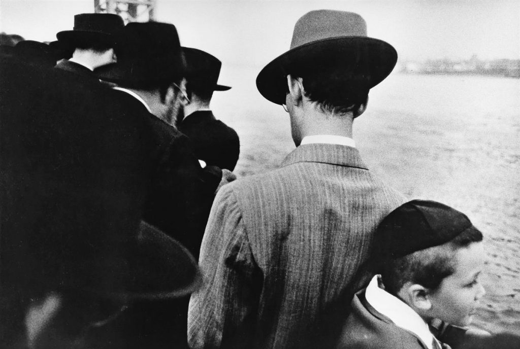 Black and white photo of Jewish men and a young boy on a ferry in New York in 1955 by Robert Frank. 