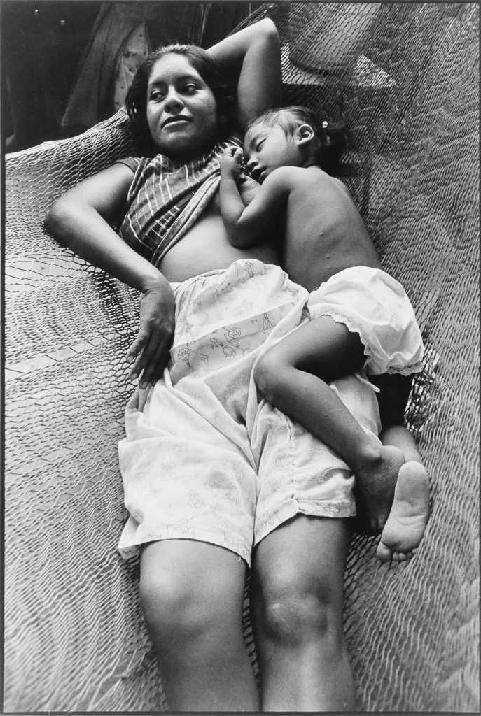 Black and white photograph of a mother and child in a hammock by Graciela Iturbide