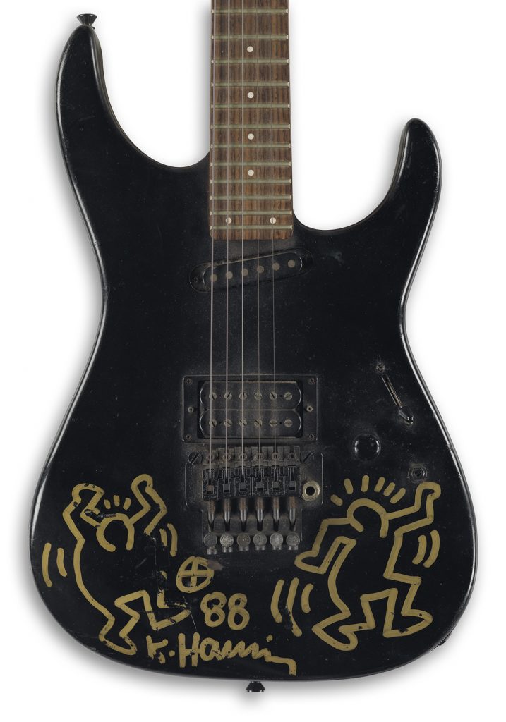 Black electric guitar with a Keith Haring drawing.