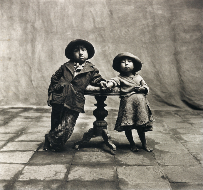 Irving Penn, Cuzco Children, Peru, December, platinum-palladium print of a little boy and girl standing holding hands across a table, 1948.